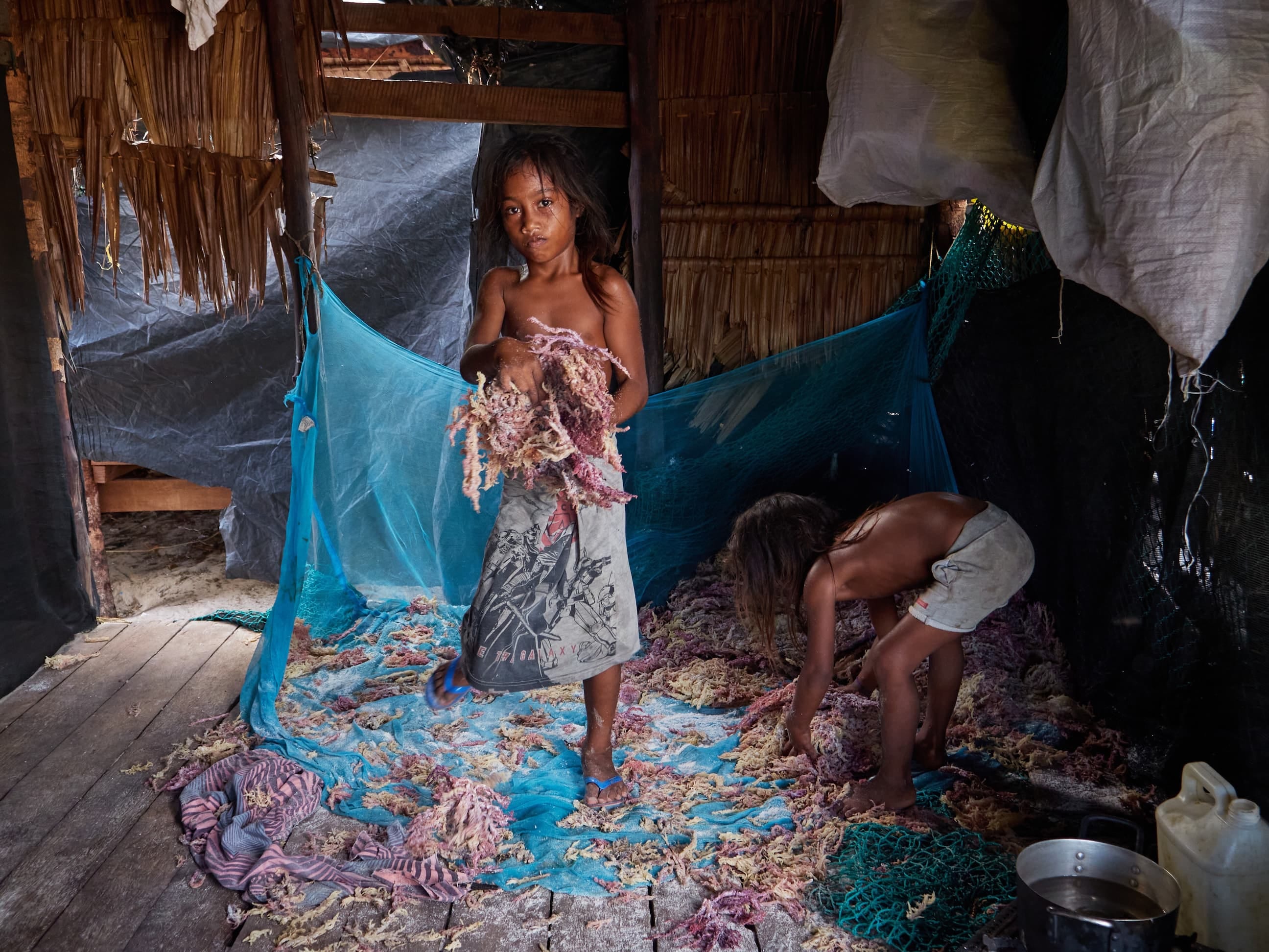 Roatasi helps her sister to pack dried seaweed for export in their extended family's home